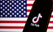 American flag displayed on a laptop screen and TikTok logo displayed on a phone screen.