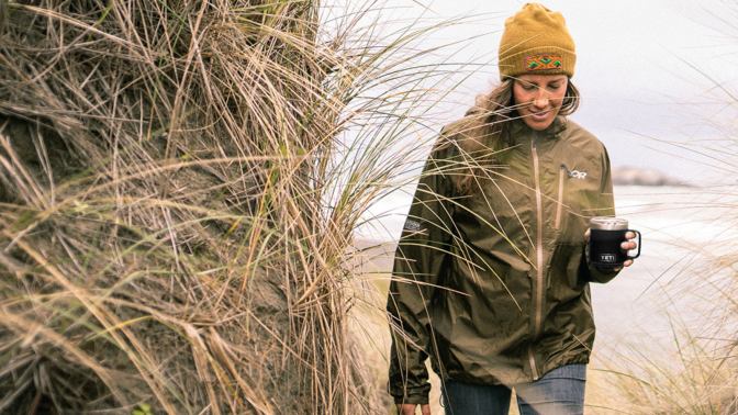 woman walking through wood with Yeti Rambler mug