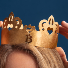 a woman's hands and the top of her head as she touches her crypto crown