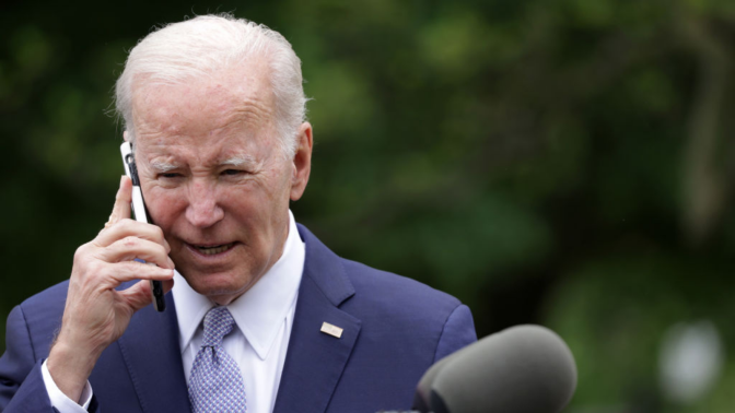 U.S. President Joe Biden talks on a cell phone during a Rose Garden event at the White House to mark National Small Business Week on May 1, 2023 in Washington, DC.