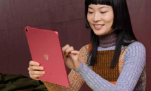 A person holding a pink iPad