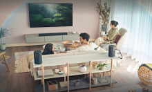 girl, man, and woman on a living watching a flatscreen TV during the day