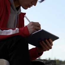 person sitting outside using apple pencil with ipad air