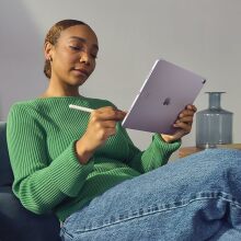 A woman sits using the Apple iPad Air 2024 release