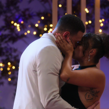 Two people kiss on the set of dating show "Love Is Blind UK".