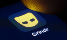 someone tapping grindr on a phone