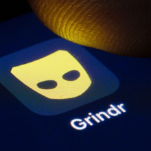 someone tapping grindr on a phone
