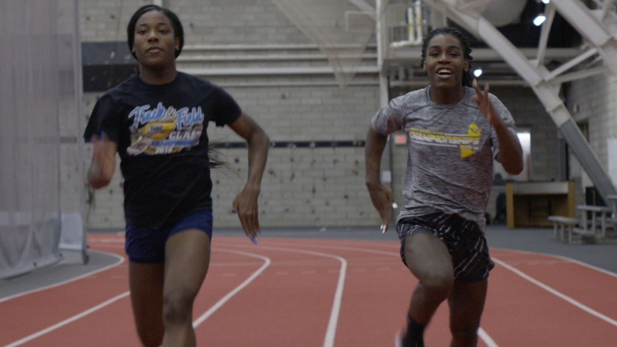 Two young Black people run on a track in "Changing the Game" 