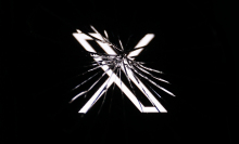 X logo behind broken glass