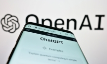 OpenAI logo with ChatGPT app on a phone