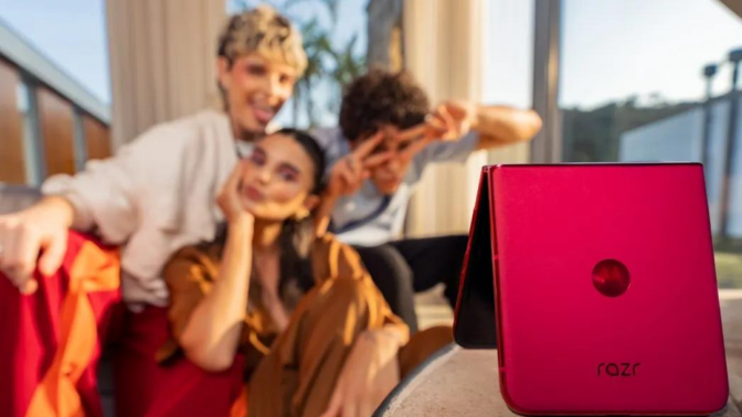 group of friends taking selfie with pink Motorola razr+ phone