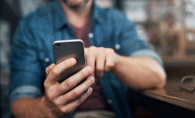 Man using a smartphone in a bar.