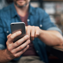 Man using a smartphone in a bar.