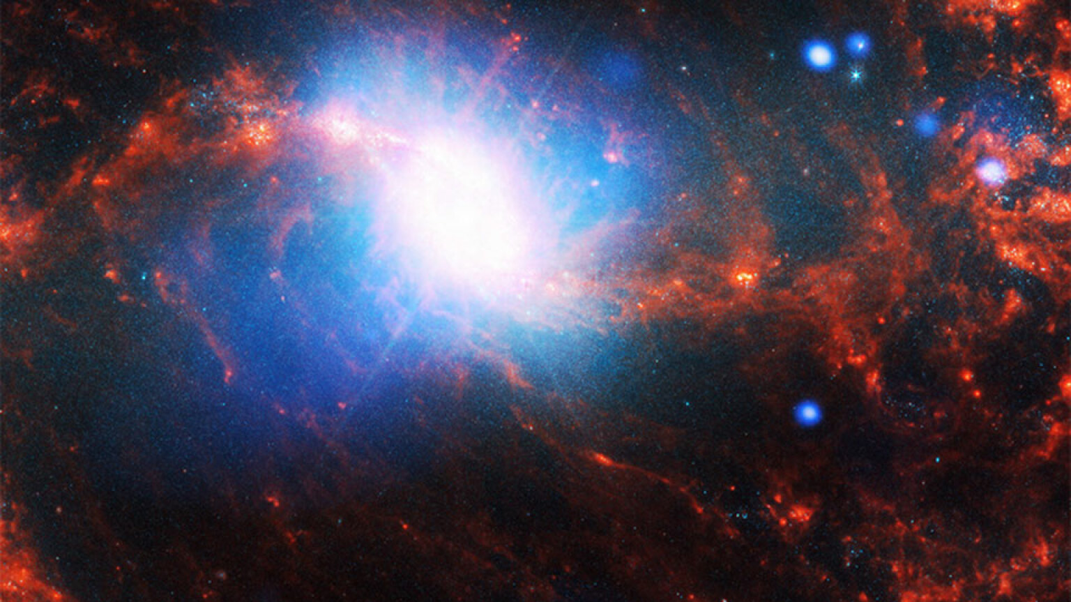 A space photo shows a spiral galaxy with a blue and white centre and orange spirals.