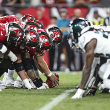 Eagles players line up on the field against the Buccaneers players.