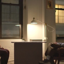 A man and a woman sit across from each other smiling in "Look Into My Eyes." 