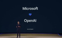 Microsoft CEO Satya Nadella in front of a screen that says Microsoft with a heart below and OpenAI