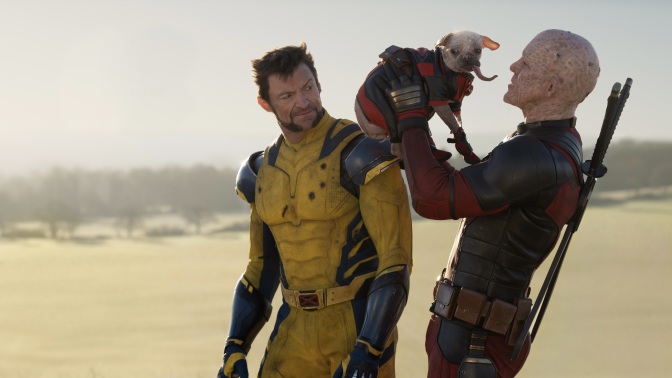 Wolverine watches on in disgust as Deadpool lifts up Dogpool.