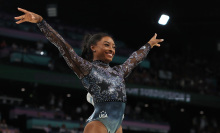 simone biles posing with arms outstretched