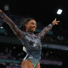 simone biles posing with arms outstretched