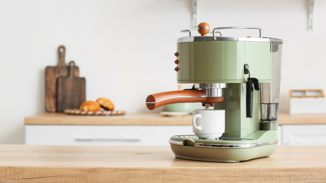 Modern coffee machine with cup on counter in kitchen