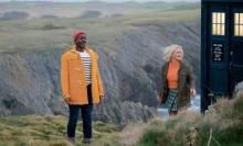 The Doctor in a yellow jacket and Ruby, on a cliff next to theTARDIS