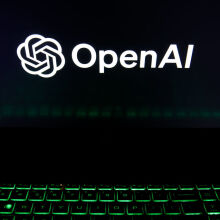 The OpenAI logo is being displayed on a laptop screen with a glowing green keyboard 