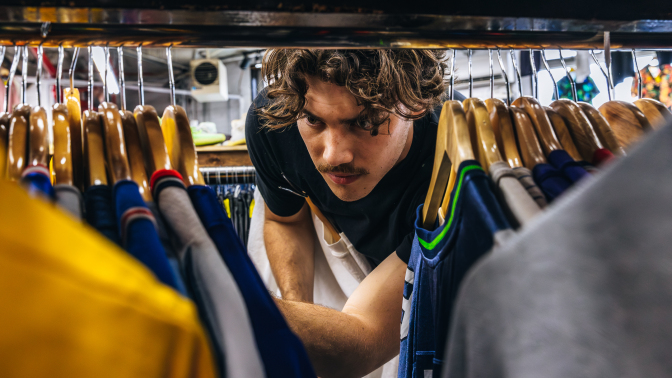 Jack Innanen looking through shirts in a thrift store in Bushwick, New York