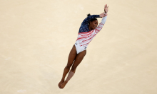 Simone Biles flies through the air during her floor routine at the 2024 Olympics. 