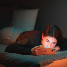 A teen watches a video on her phone.