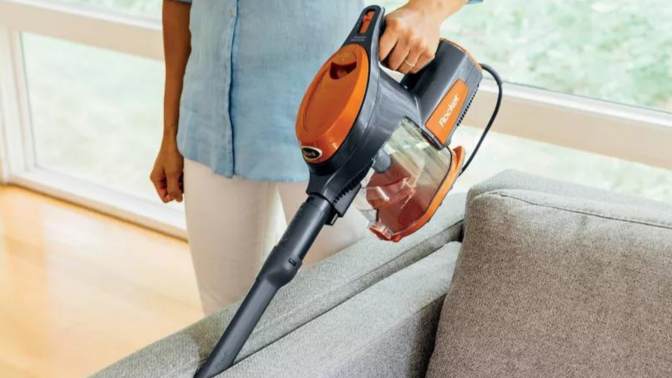 person vacuuming couch with Shark vacuum 