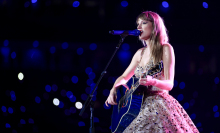 Taylor Swift performing with her guitar on stage at The Eras Tour