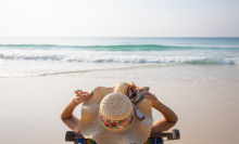 woman laying on beach in sun hat