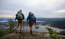 two men looking off a cliff into the distance 