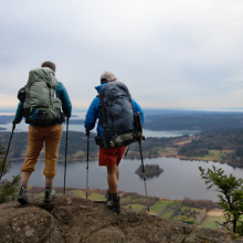 two men looking off a cliff into the distance 