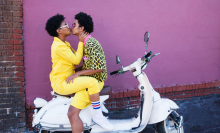 Young couple kissing on the back of a scooter