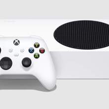 an xbox wireless controller leaning up against an xbox series s on a gray background