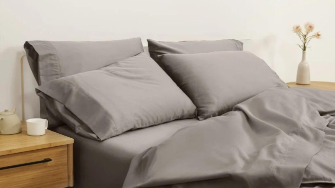 Bed with gray bedding and nightstands in peripheral view