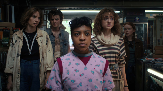 A group of 5 teenagers in '80s clothing stand in a store.