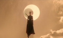 A woman with a sword at her back floats through an orange sky against a symbol of three interlocking circles.