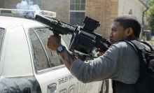 Terry Richmond fires a gun over a cop car.