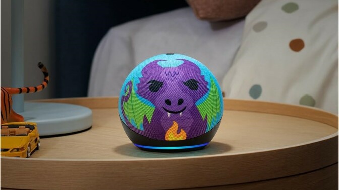an echo dot kids with a dragon design sits on a nightstand next to a bed with polka dot sheets