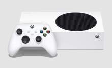 the xbox series s lying flat next to an xbox wireless controller