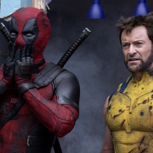 Deadpool and Wolverine standing together in a grey room.