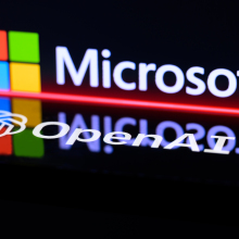 The OpenAI and Microsoft logos projected on a shiny black wall. 