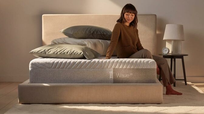 Woman sits on a Casper Sleep Wave Memory Foam mattress.