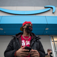 Union organizer Chris Smalls stands in front of the Amazon logo.