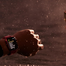 A person swimming in the water looking at an Apple Watch 9 on their wrist.