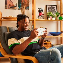 Man sits in a chair playing a game on the Asus ROG Ally