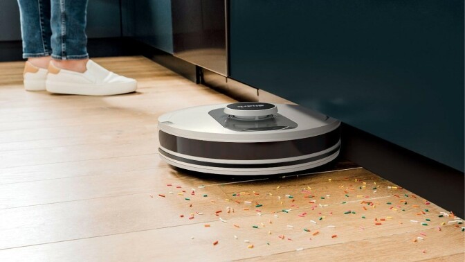 the shark AI ultra robot vacuum picks up colorful sprinkles on a hardwood floor